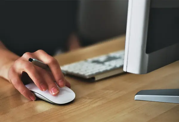 Woman’s hand holding a computer mouse